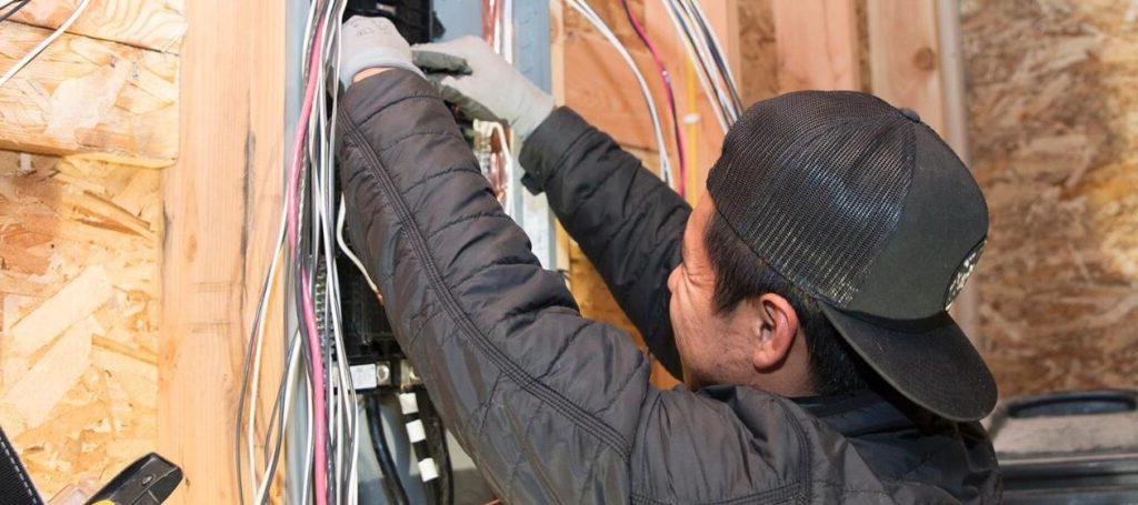 A student installing a breaker box